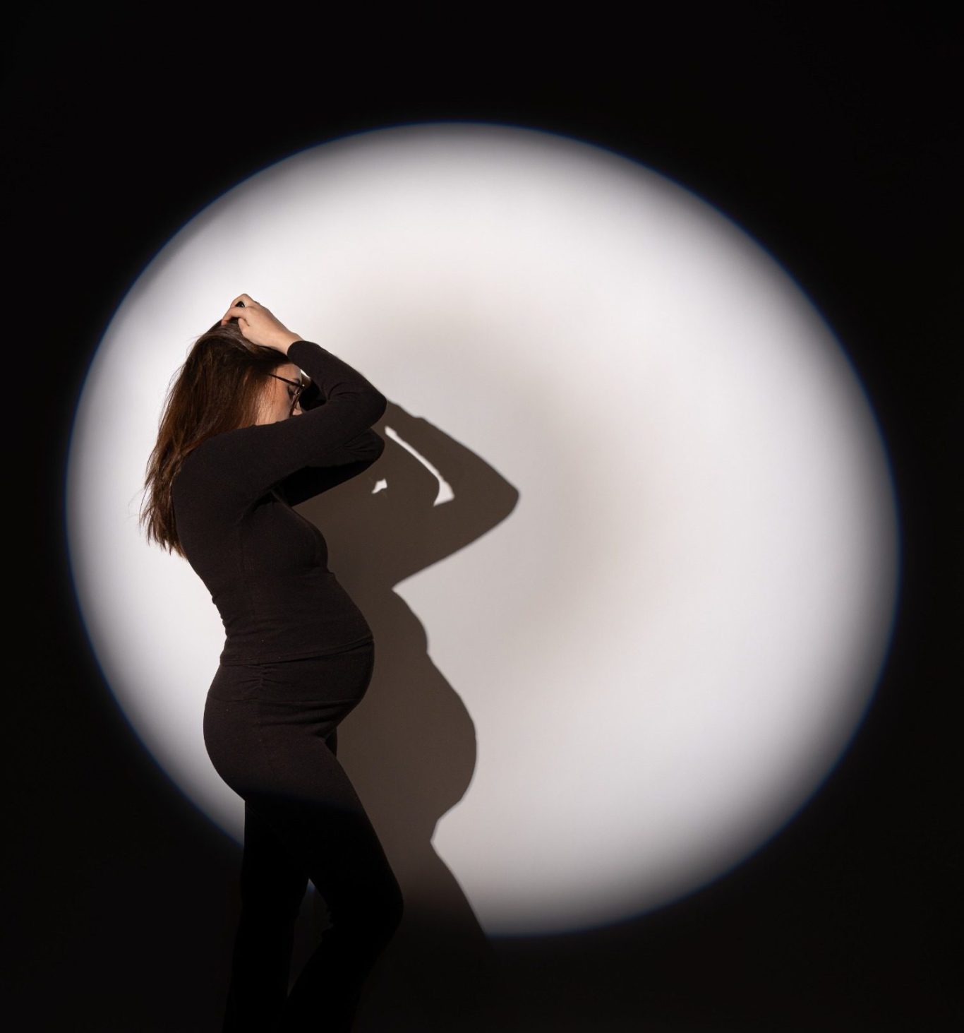 Spotlight Session bei AuraMirror Frau im Spotlight-Licht vor dunklem Hintergrund im Studio
